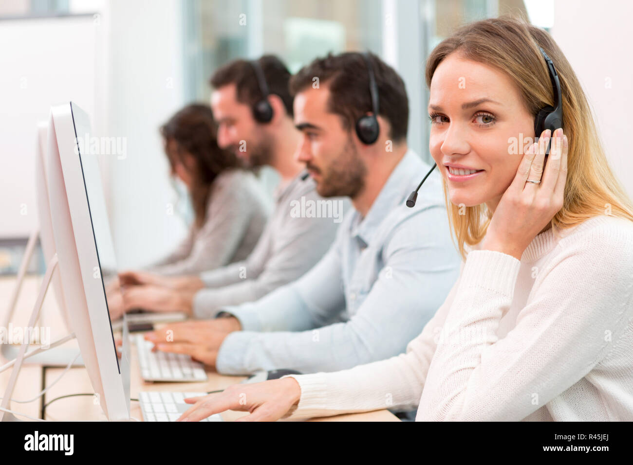 Giovane donna attraente che lavorano in un call center Foto Stock