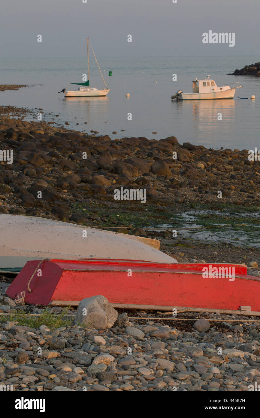 Le barche in acqua, skiffs sul litorale, spiaggia rocciosa. Red skiff. Segale si è trasformata in una ricca comunità di spiaggia sul New Hampshire costa, pesca. Foto Stock