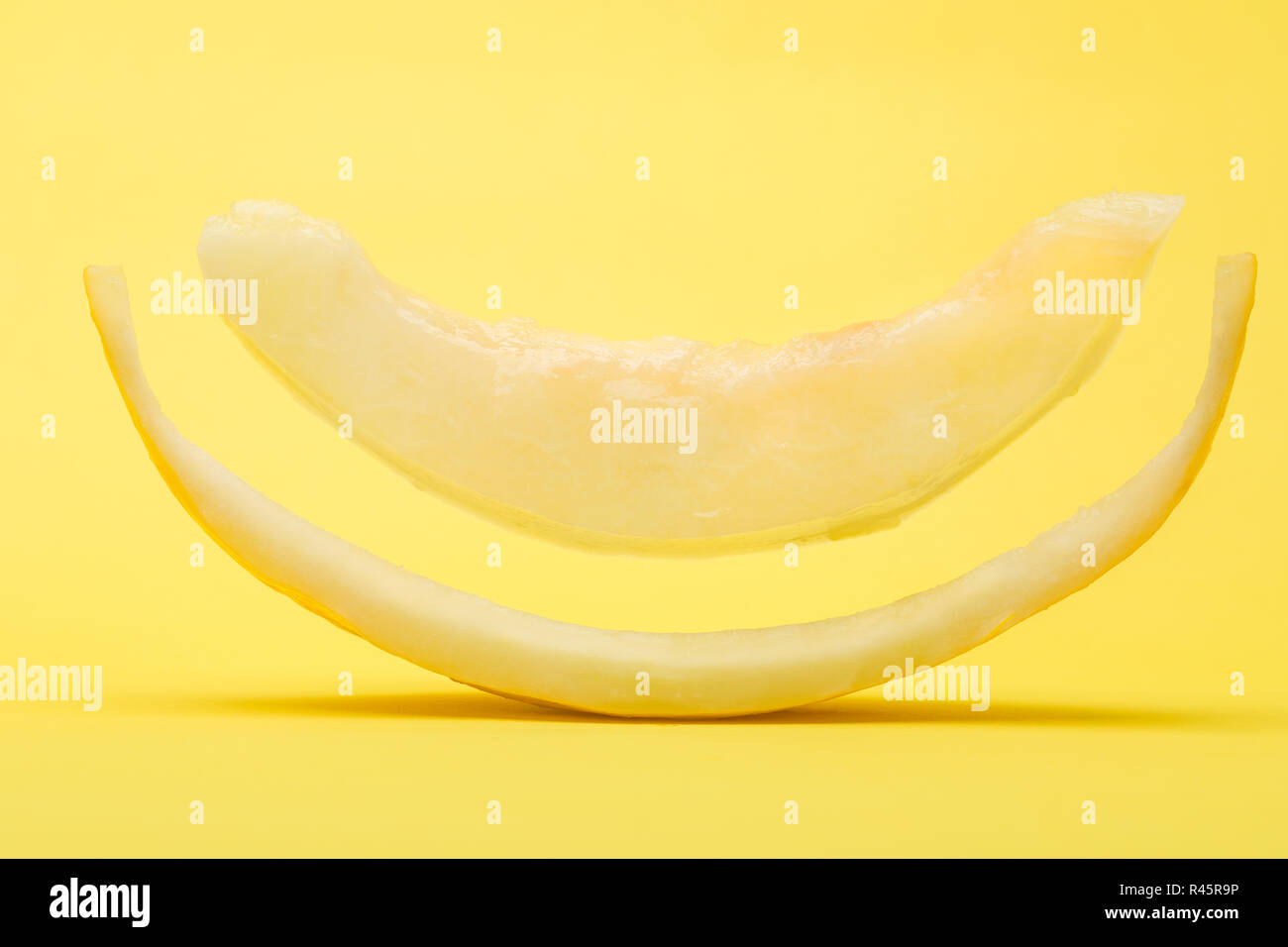 Floating fetta di melone Canarie su sfondo giallo Foto Stock