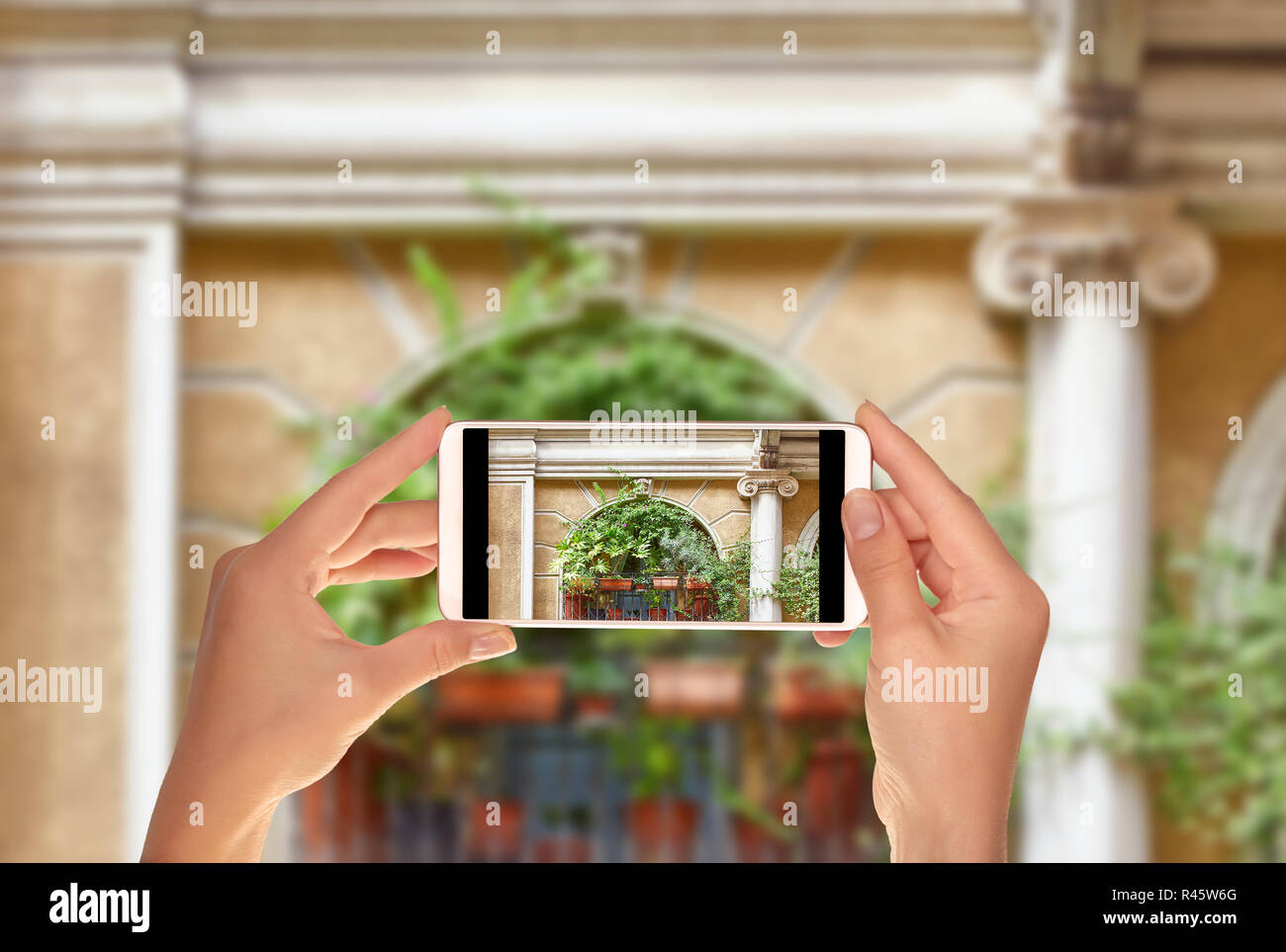 Un turista è scattare una foto del balcone con varie specie di fiori e piante milano, Italia su un telefono cellulare Foto Stock