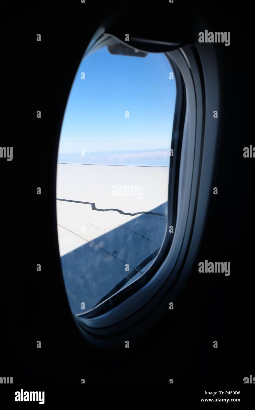 Un aereo finestra con vista parziale di un parafango e il cielo. Foto Stock