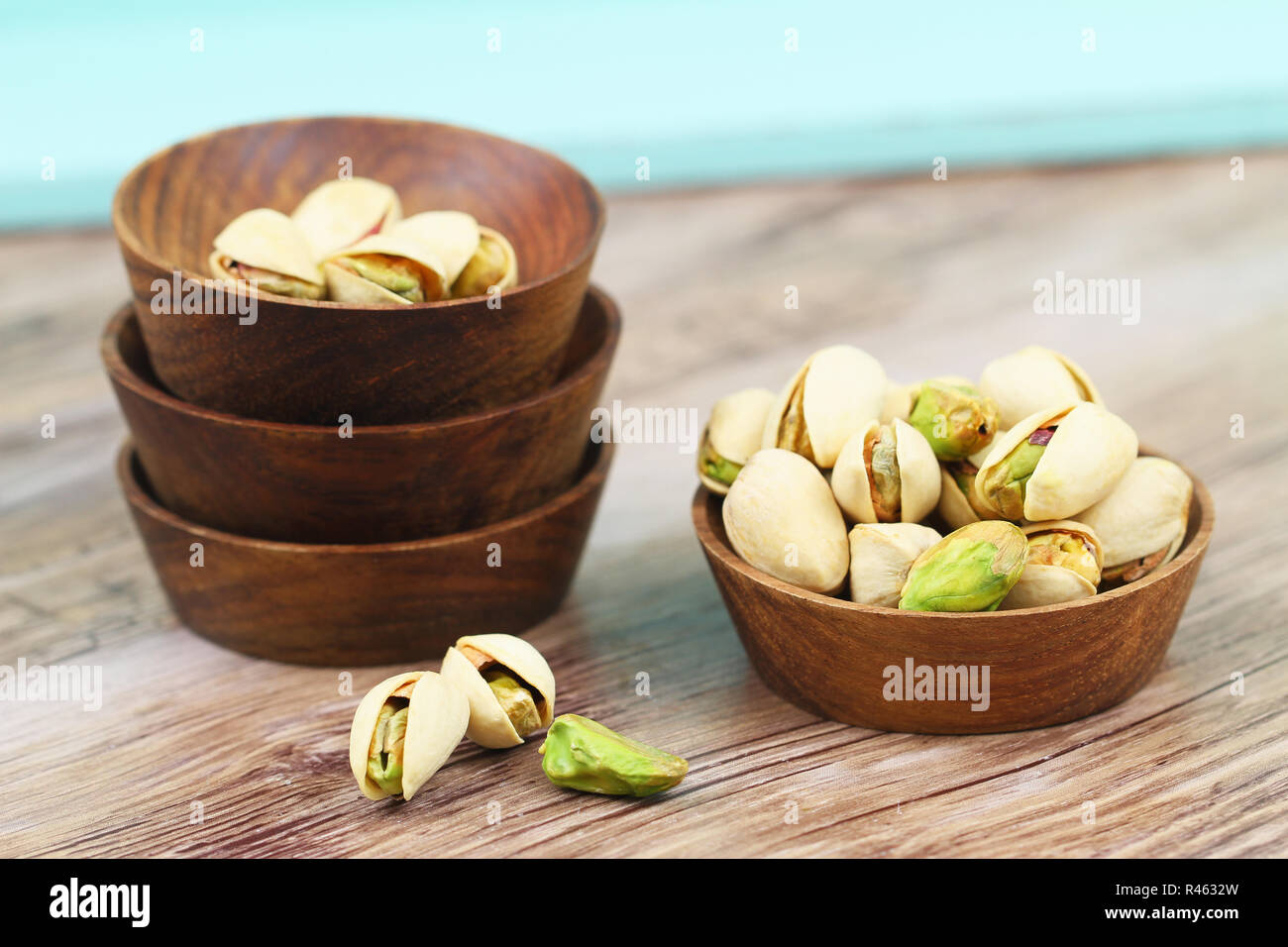 I pistacchi con e senza guscio in ciotole di legno Foto Stock