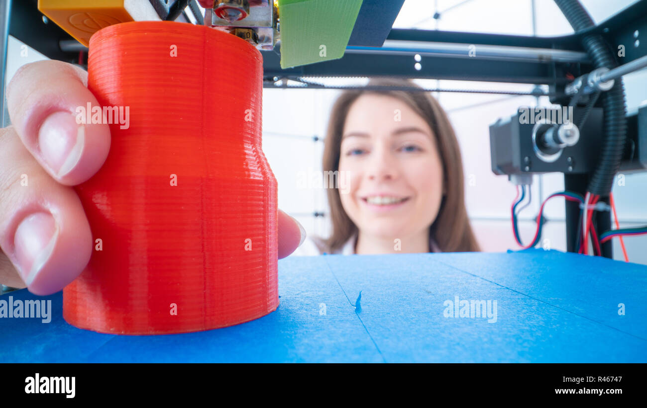 Giovani donne designer in 3d laboratorio di stampa. Ragazzina prende il particolare finito dalla stampante 3D Foto Stock