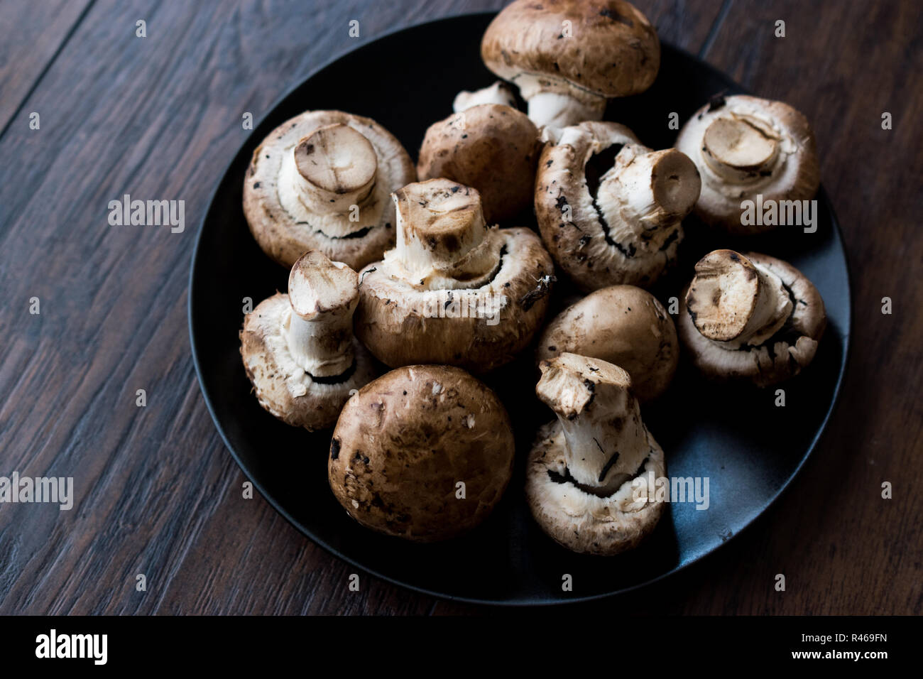 Portobello Raw funghi cremini nella piastra nera. Alimenti biologici. Foto Stock
