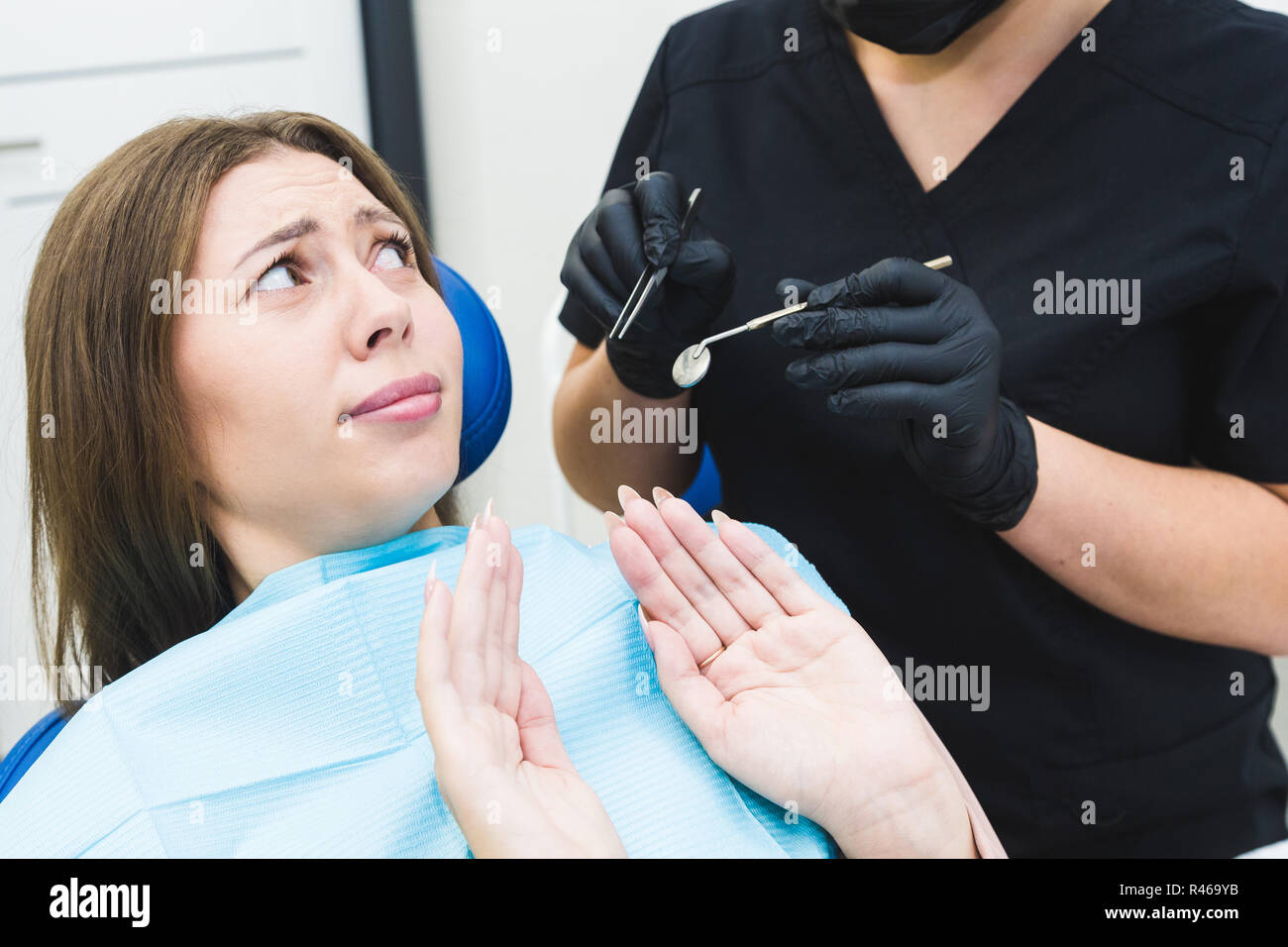 Dental Clinic. Reception, l'esame del paziente. La cura dei denti. Giovane donna si sente paura presso il dentista Foto Stock