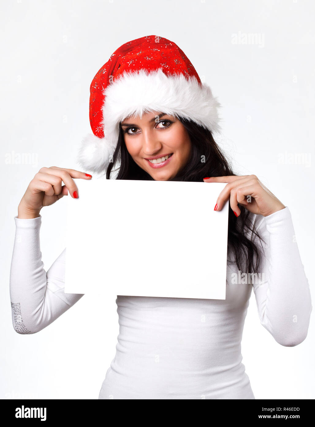 Bella ragazza in un berretto di Babbo Natale con un foglio di carta Foto Stock