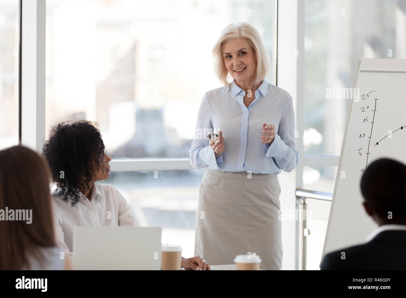 Femmina matura business coach intervenendo alla riunione del team Formazione s Foto Stock