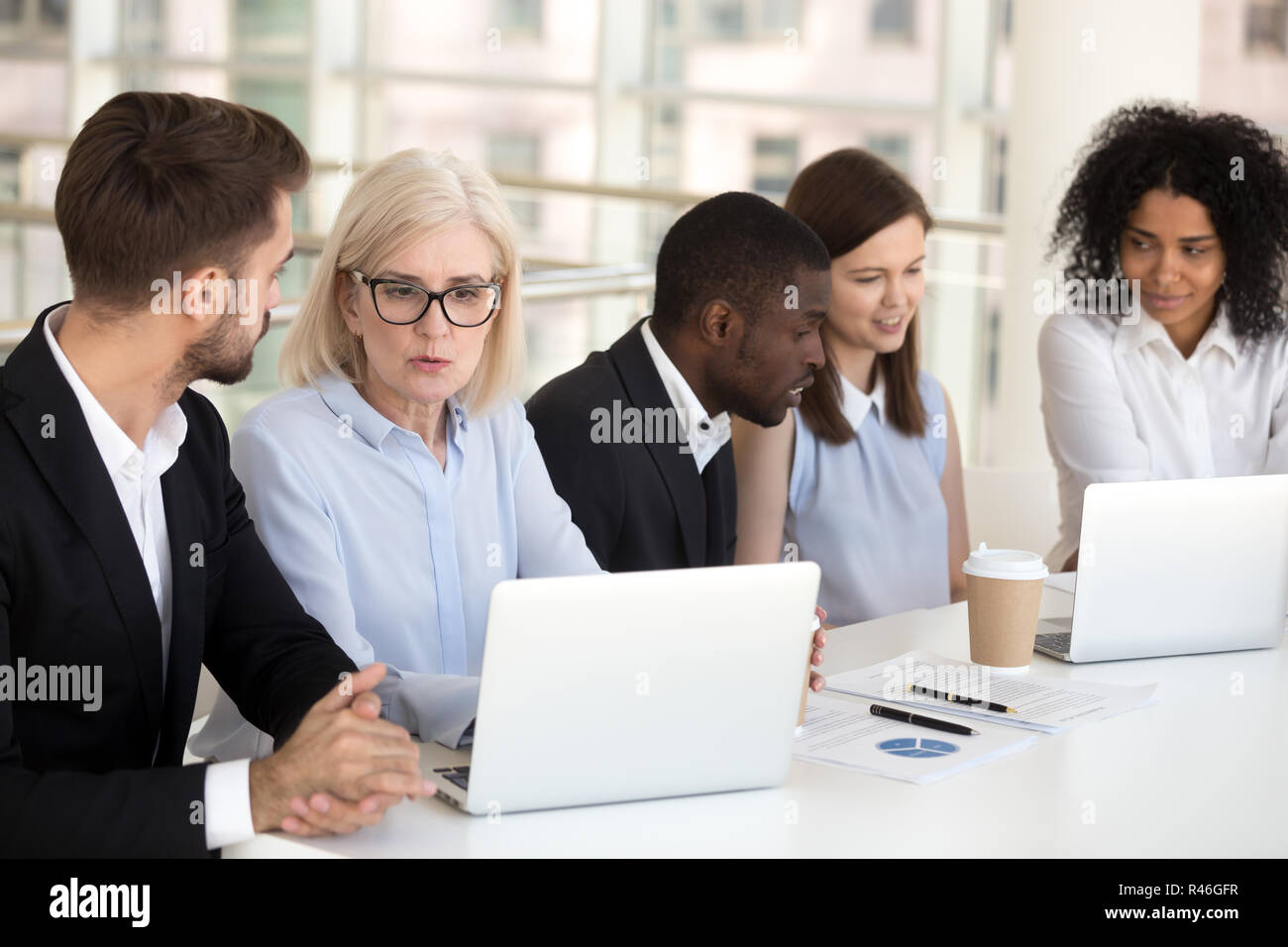 Gravi concentrati diversi dipendenti in sede di gruppo di lavoro conversazione o Foto Stock