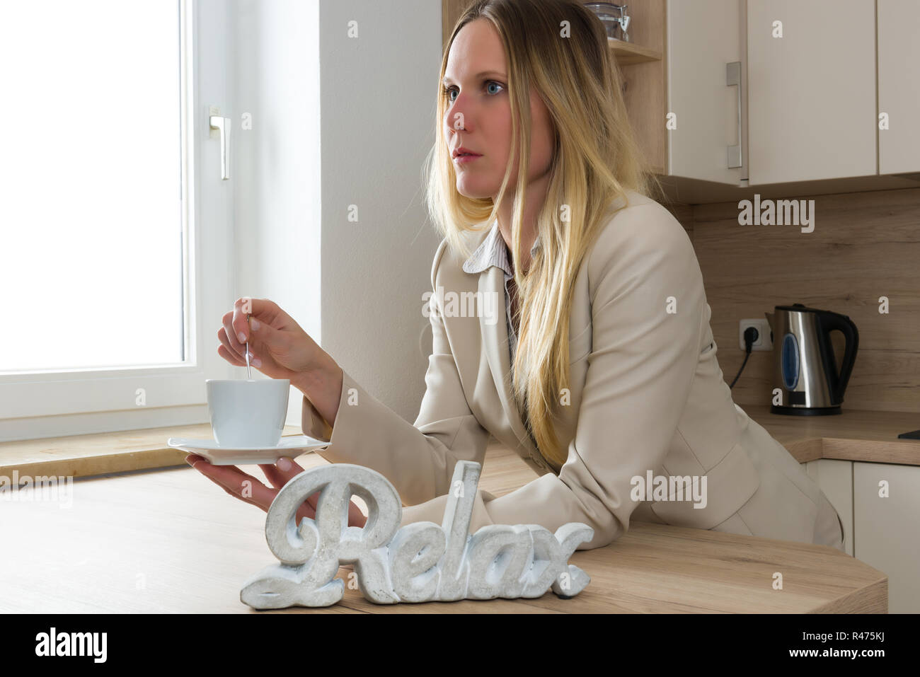 Business donna rilassarsi con una tazza di caffè in cucina Foto Stock