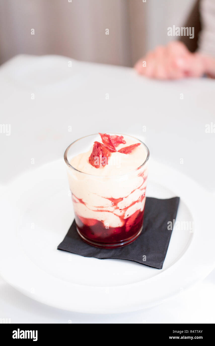 Deliziosi dessert in vetro con panna e fragola Foto Stock