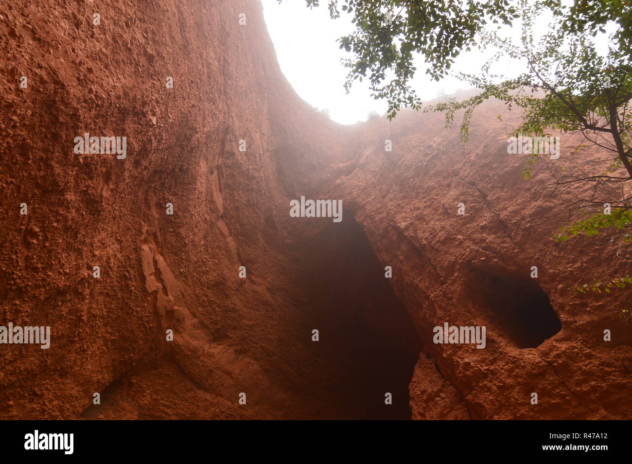 Parete erosa con fori della Cuevona nel Medulas romano ex miniera d'oro in un giorno con un sacco di nebbia in Medulas. Natura, viaggi, paesaggi, la sua Foto Stock