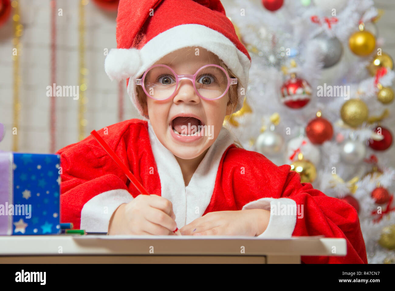 Ragazza grida felicemente disegno carta regalo come un regalo per Natale Foto Stock