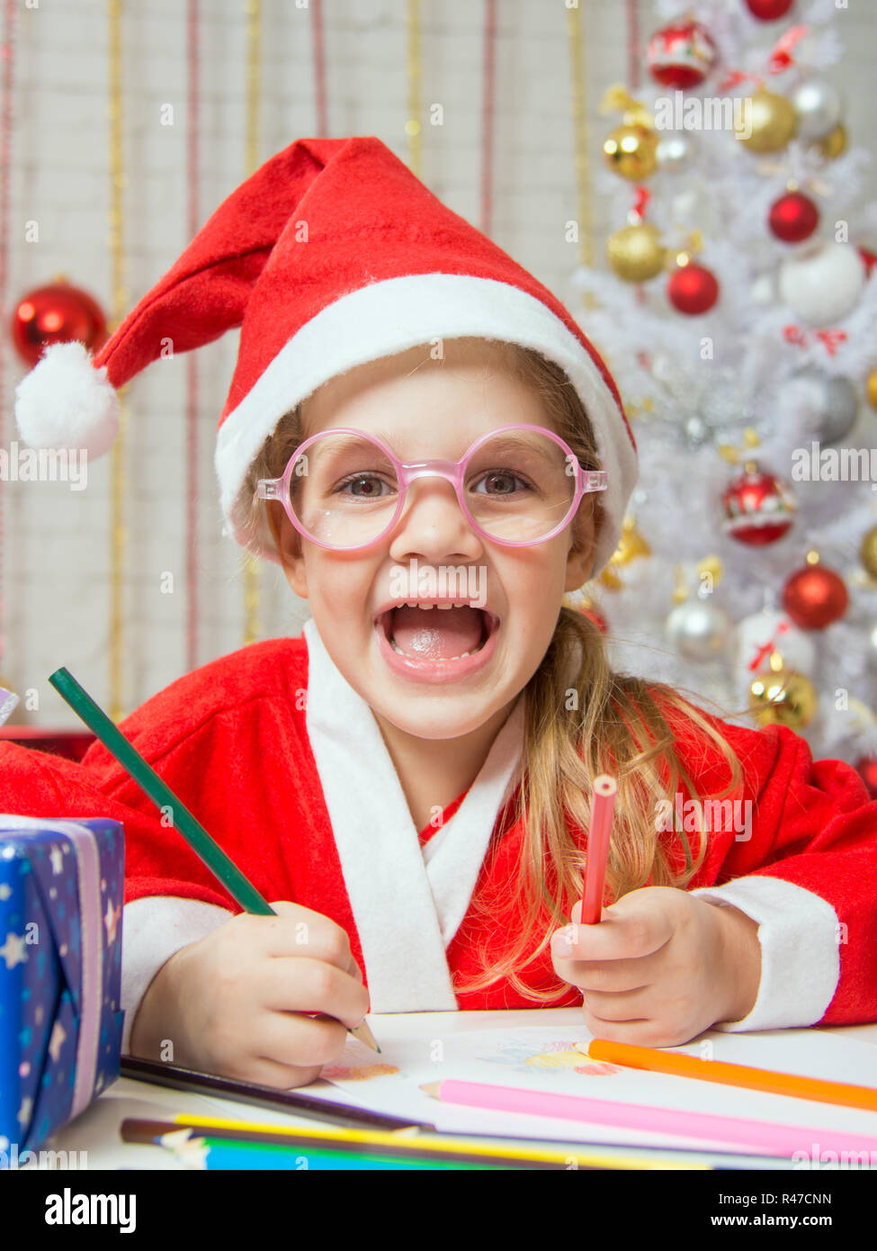Ragazza sorridente felicemente disegno carta regalo come un regalo per Natale Foto Stock