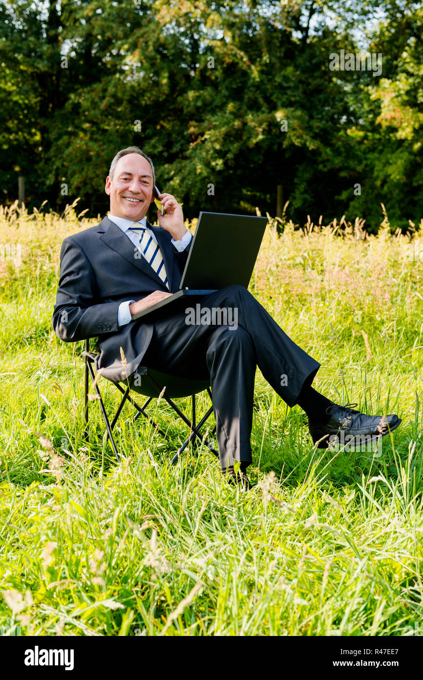 Business man sul prato - green it Foto Stock
