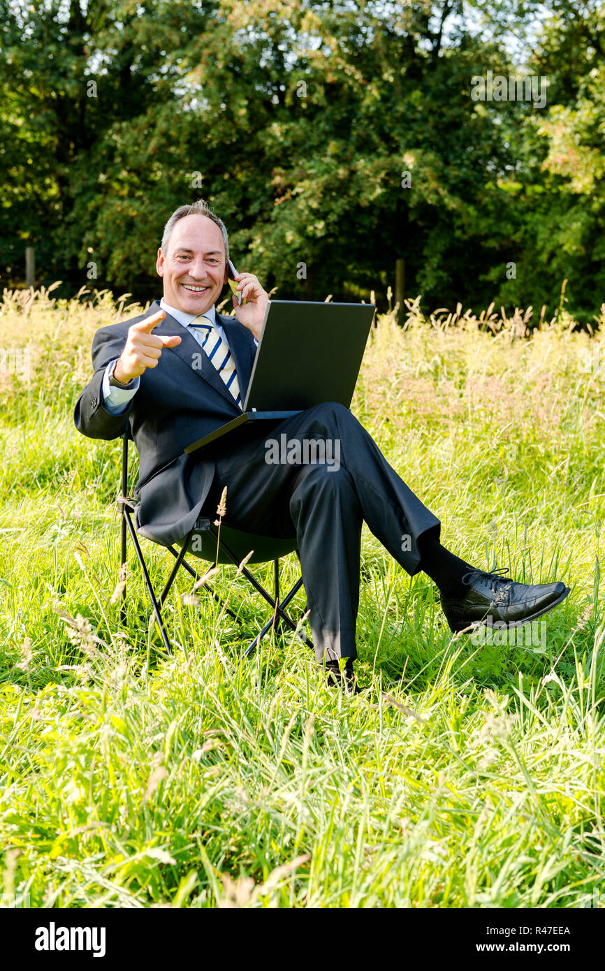 Business man sul prato - green it Foto Stock
