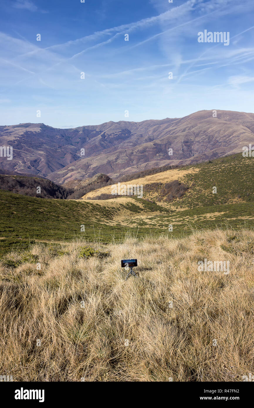 Smart mobile phone su un treppiede piccolo prendendo un lasso di tempo di un grandioso altipiani della vecchia montagna e vertice Midzor in Serbia Foto Stock