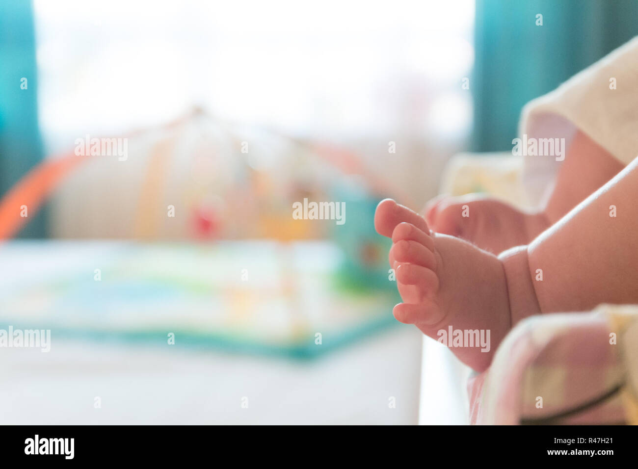 Il piccolo piccolo grazioso piede del neonato. Sfocato sfondo luminoso. Foto Stock