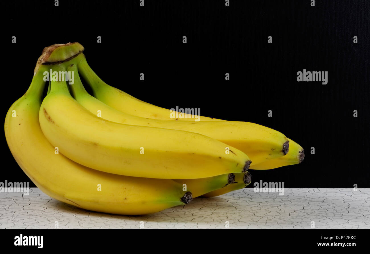Un grappolo di banane quasi mature Foto Stock