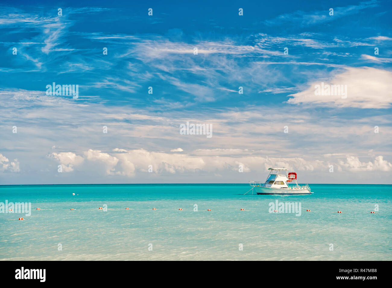 Barca alla spiaggia di Marina di Antigua St. Johns con la barca in acqua blu e il cielo con le nuvole di piccole dimensioni Foto Stock