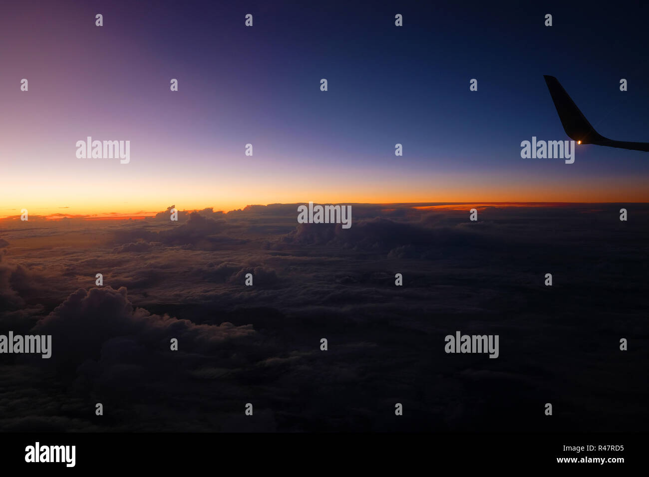 Ala di un piano di fronte a un bel tramonto sopra le nuvole Foto Stock