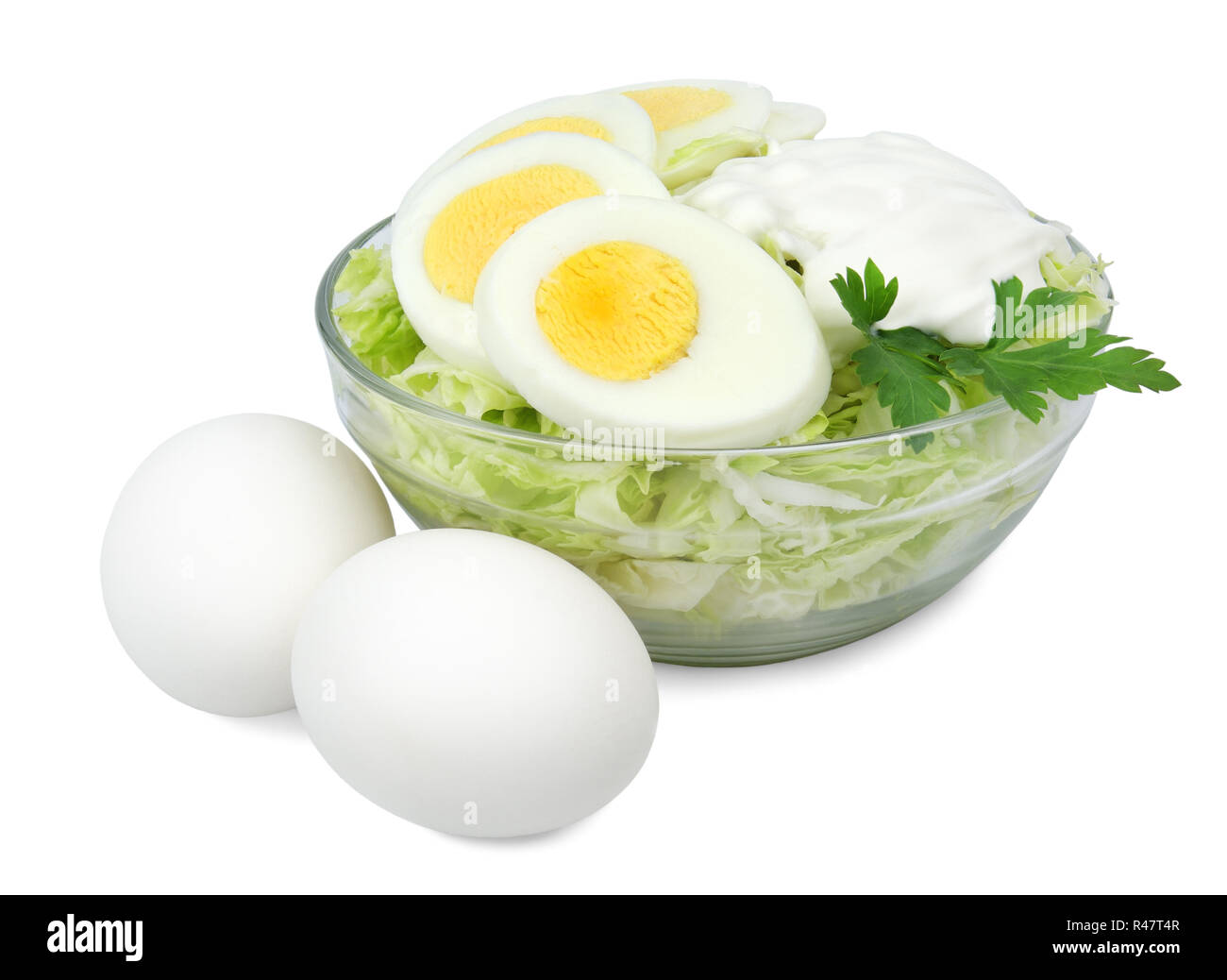 Vaso di vetro con una insalata di cavolo uova sode e panna acida isolati su sfondo bianco. Foto Stock