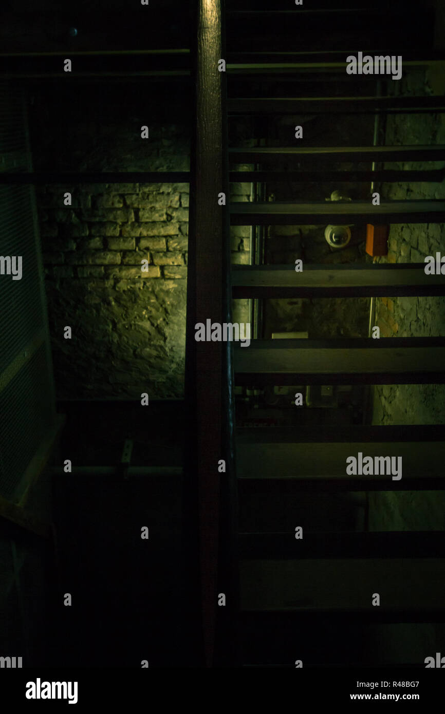 Un vecchio pericolosi scala in legno conduce al buio dungeon Foto Stock