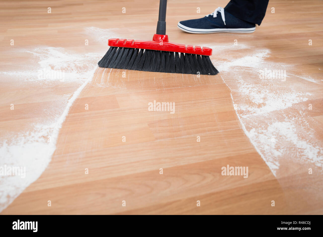 L'uomo spazzare il pavimento di legno duro Foto Stock