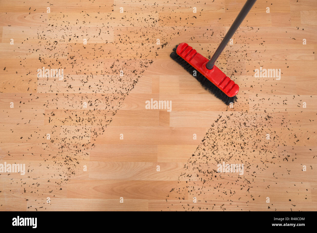 Pulitura della scopa sporco sul pavimento di legno duro Foto Stock