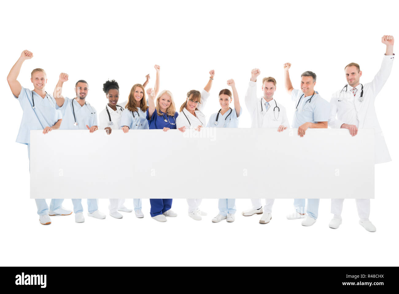 Happy Team Medico con le braccia sollevate Holding tabellone vuoto Foto Stock