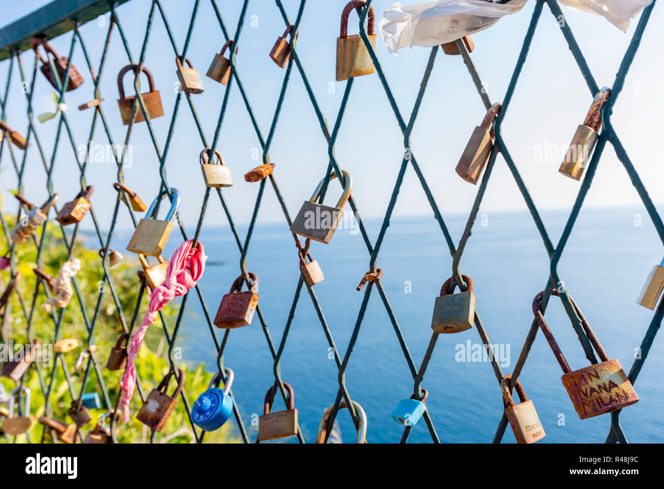 La chiusura si blocca sulla griglia sullo sfondo del mare blu e un simbolo di fedeltà e di amore eterno Foto Stock