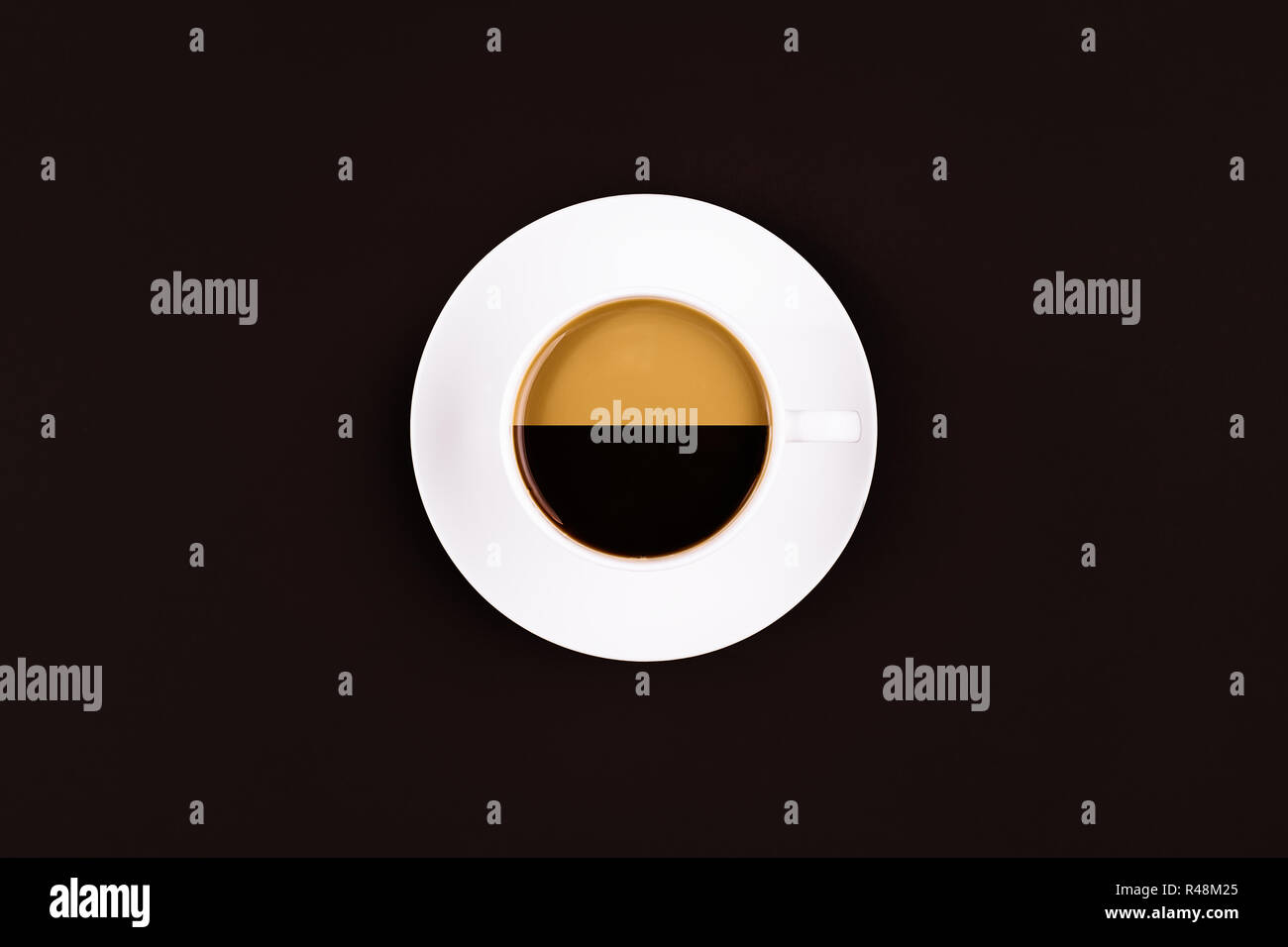 Una tazza da caffè con due diversi tipi di caffè in essa su sfondo scuro Foto Stock