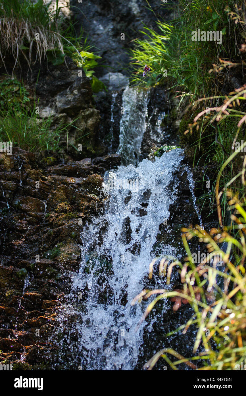 Fresco, acqua chiara sgorga giù cascate lungo un flusso Foto Stock