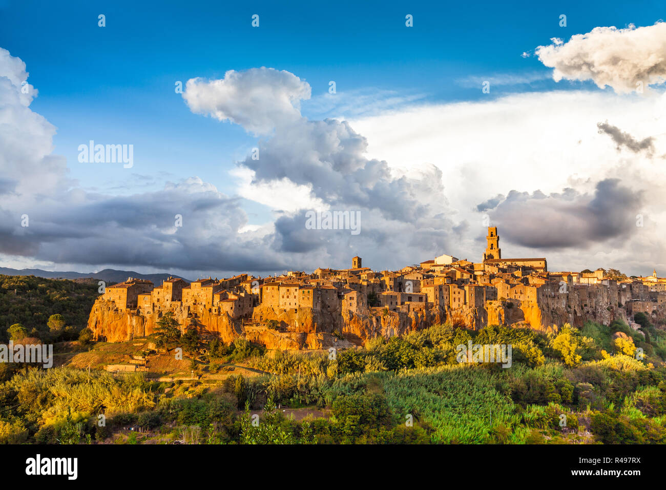 La città medievale di Pitigliano con drammatica cloudscape al tramonto, Toscana, Italia Foto Stock