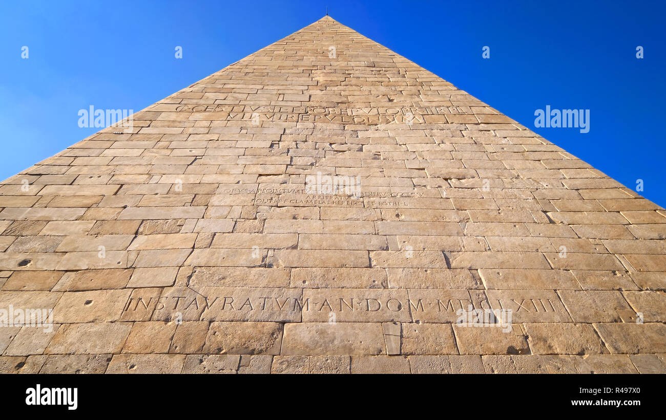 Antico Romano Piramide Cestia contro il cielo blu a Roma, Italia Foto Stock