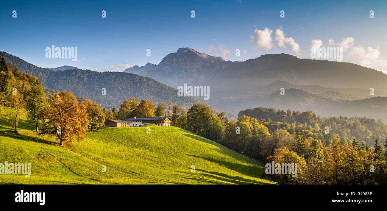 Bellissimo paesaggio autunnale con tradizionale agriturismo nelle Alpi nel golden luce della sera Foto Stock