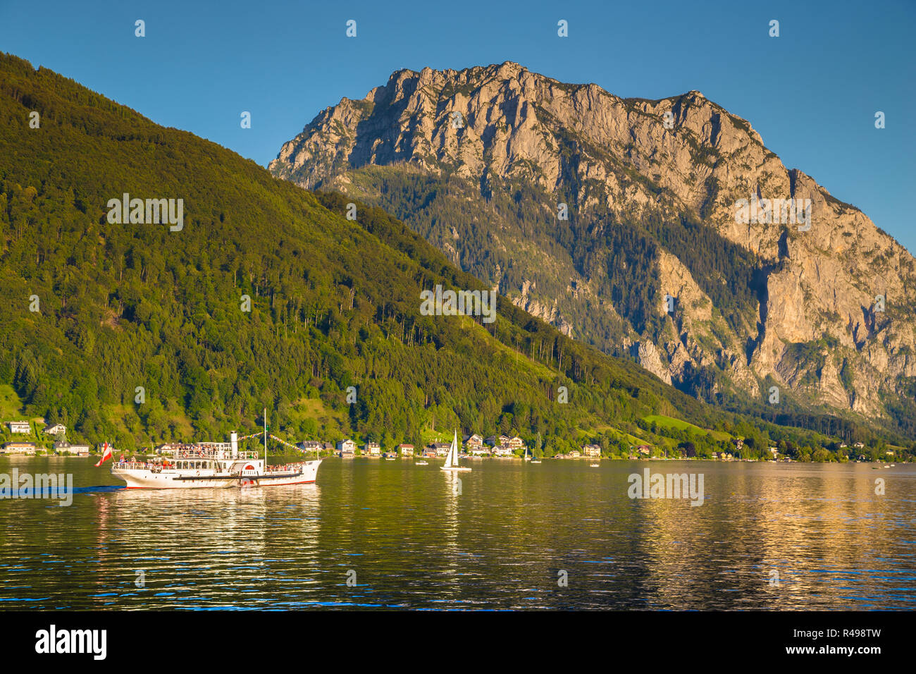 Bellissima vista della tradizionale battello a vapore escursione nave sul Lago Traunsee con il famoso Traunstein mountain in background al tramonto in estate, gm Foto Stock