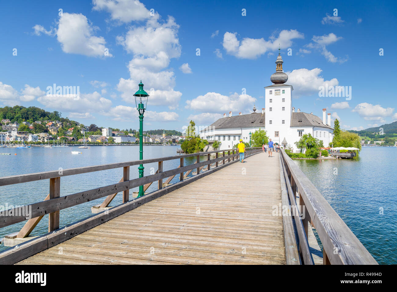 Bellissima vista del famoso Schloss Ort con ponte in legno sul Lago Traunsee in una giornata di sole con cielo blu e nuvole in estate, Gmunden, Salzkammergut Foto Stock