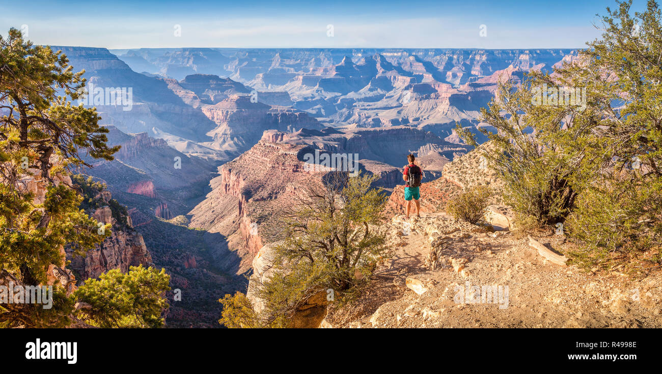 Vista panoramica di giovani escursionista affacciato sulla famosa Grand Canyon in beautiful Golden luce della sera al tramonto in estate, Arizona, Stati Uniti d'America Foto Stock