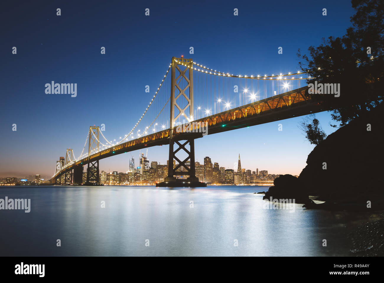 Visualizzazione classica della skyline di San Francisco con il famoso Oakland Bay Bridge illuminato nel bellissimo crepuscolo serale al tramonto in estate, San Francisco Foto Stock