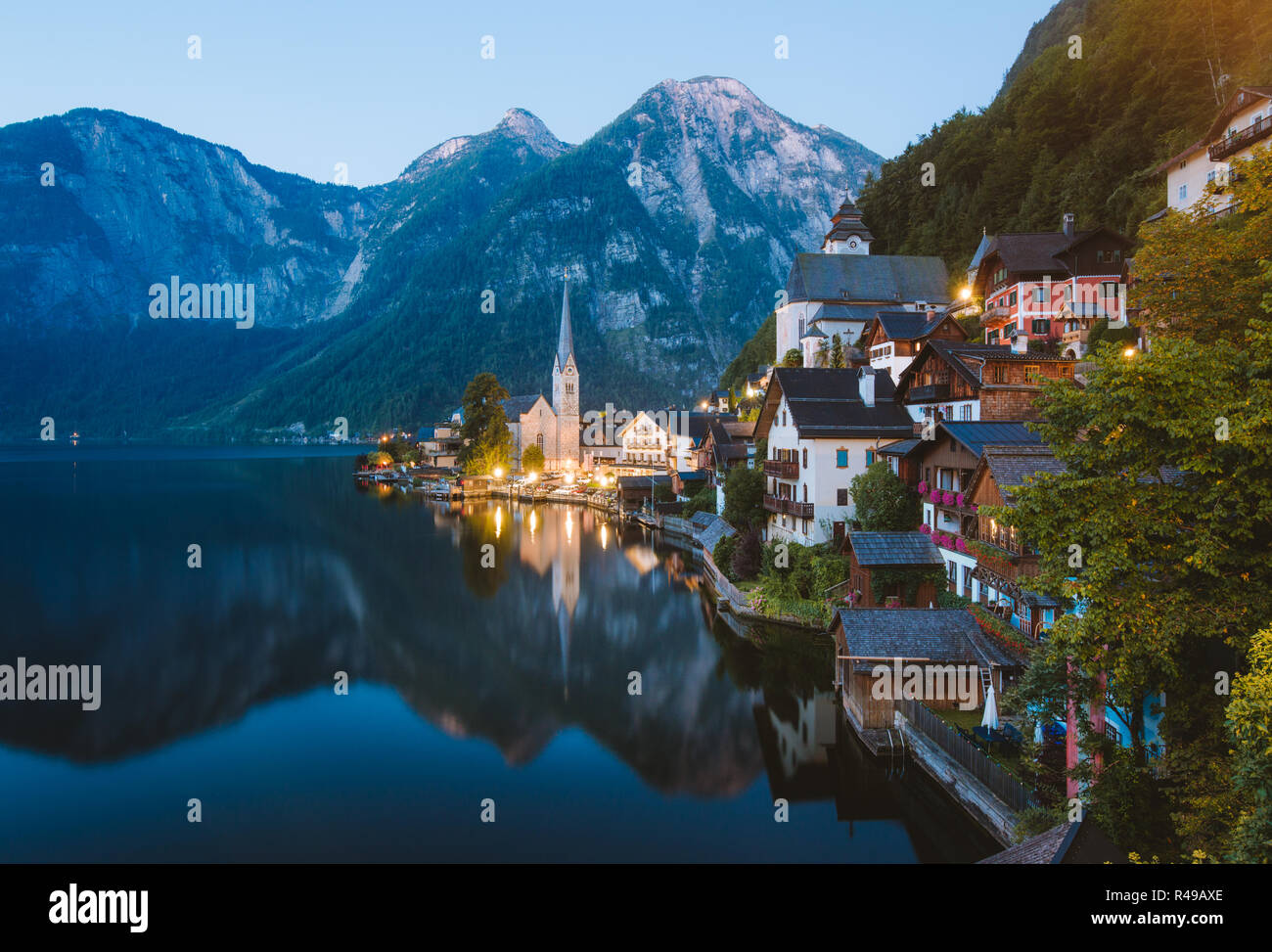 Classic vista da cartolina famosa Hallstatt villaggio di montagna con Hallstattersee nelle Alpi austriache a mystic twilight durante ore blu all'alba nella somma Foto Stock