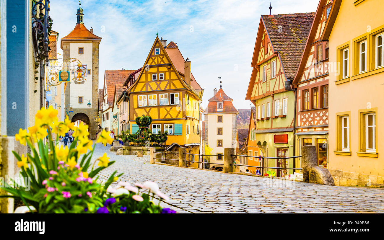 La città medievale di Rothenburg ob der Tauber con fiori che sbocciano in una bella giornata di sole con cielo blu e nuvole, Baviera, Germania Foto Stock