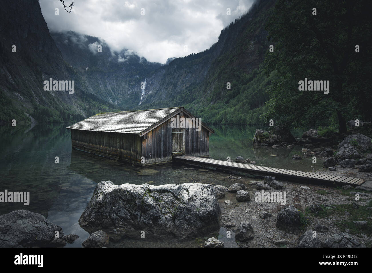 Vista panoramica tradizionale antica imbarcazione in legno house presso il pittoresco lago Obersee su una bella giornata con cielo blu e nuvole in estate, Baviera, Germania Foto Stock