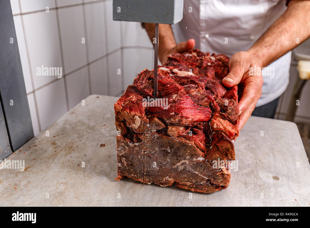 Trasformazione della carne in fabbrica, Butcher lavora con carni congelate Foto Stock