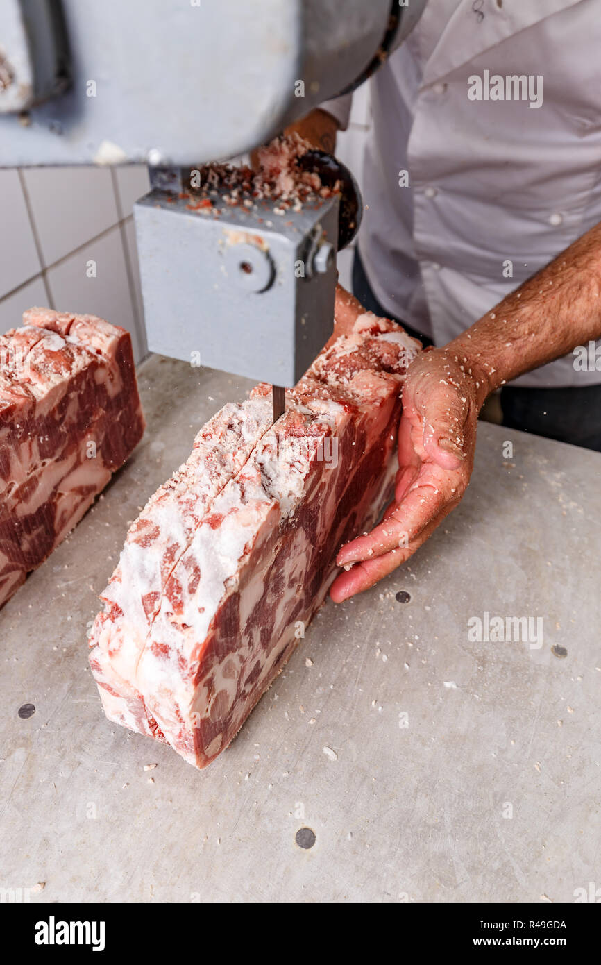 Trasformazione industriale dei prodotti alimentari il taglio alla macchina utensile congelati costolette di maiale Foto Stock