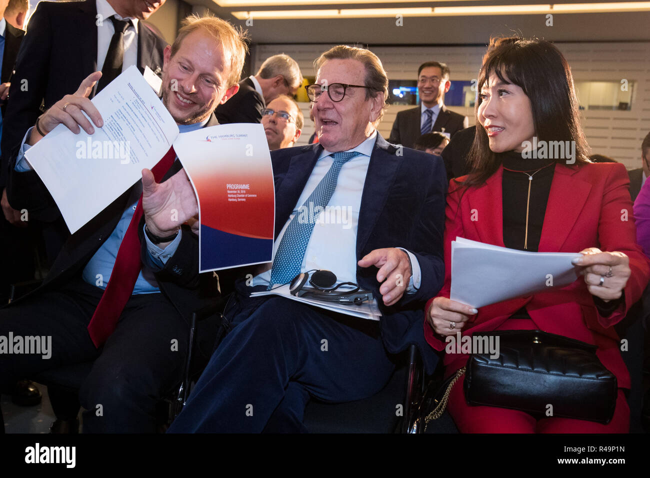 Amburgo, Germania. 26 Nov, 2018. L'ex Cancelliere federale Gerhard Schröder (SPD), sua moglie Soyeon Schröder-Kim (r) e Tobias Bergmann (l), Presidente della Camera di Commercio di Amburgo, parlare prima della apertura della conferenza "Il Vertice di Amburgo - Cina incontra l'Europa" alla Camera di Commercio di Amburgo. L'interdipendenza economica globale è uno dei temi principali della conferenza, che si svolgerà per l'ottava volta in Camera di Commercio. Credito: Christian Charisius/dpa/Alamy Live News Foto Stock