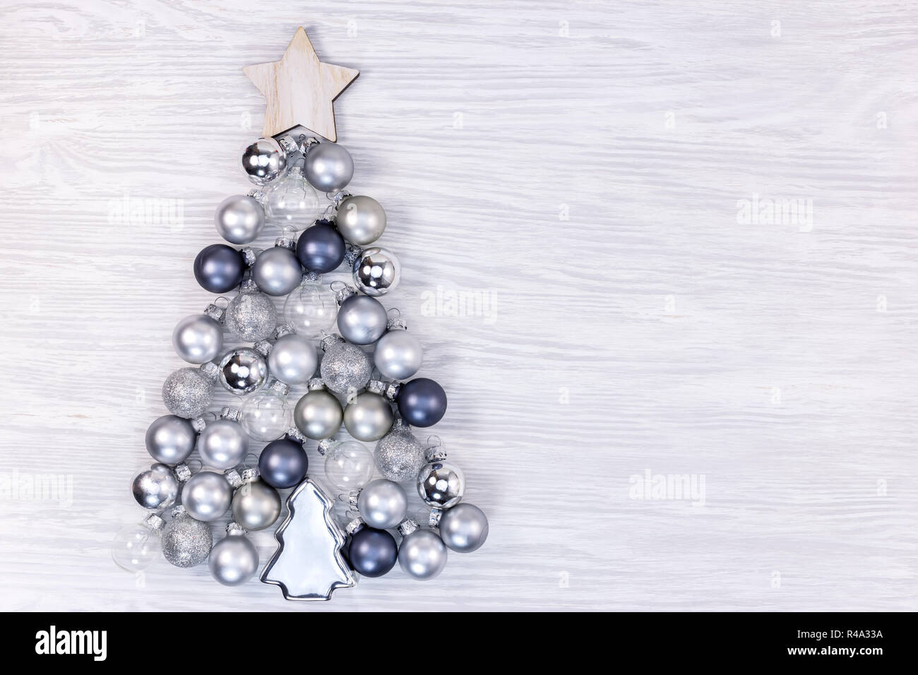 Albero di Natale fatto di diverso colore di piccole sfere di vetro bianco su sfondo rustico Foto Stock