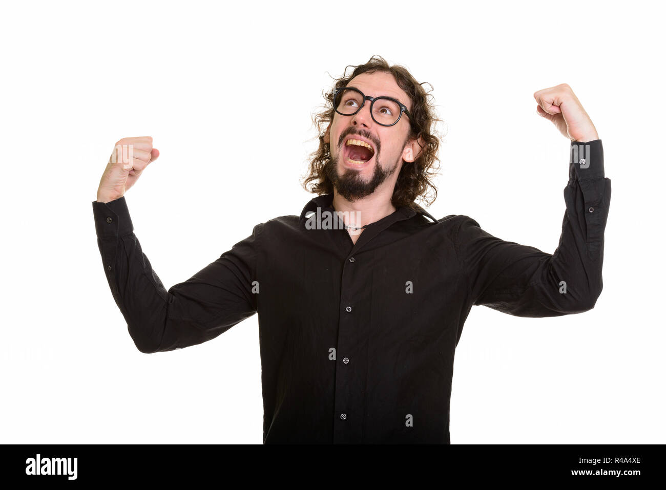 Felice bello uomo caucasico guardando eccitato con bracci sollevati Foto Stock