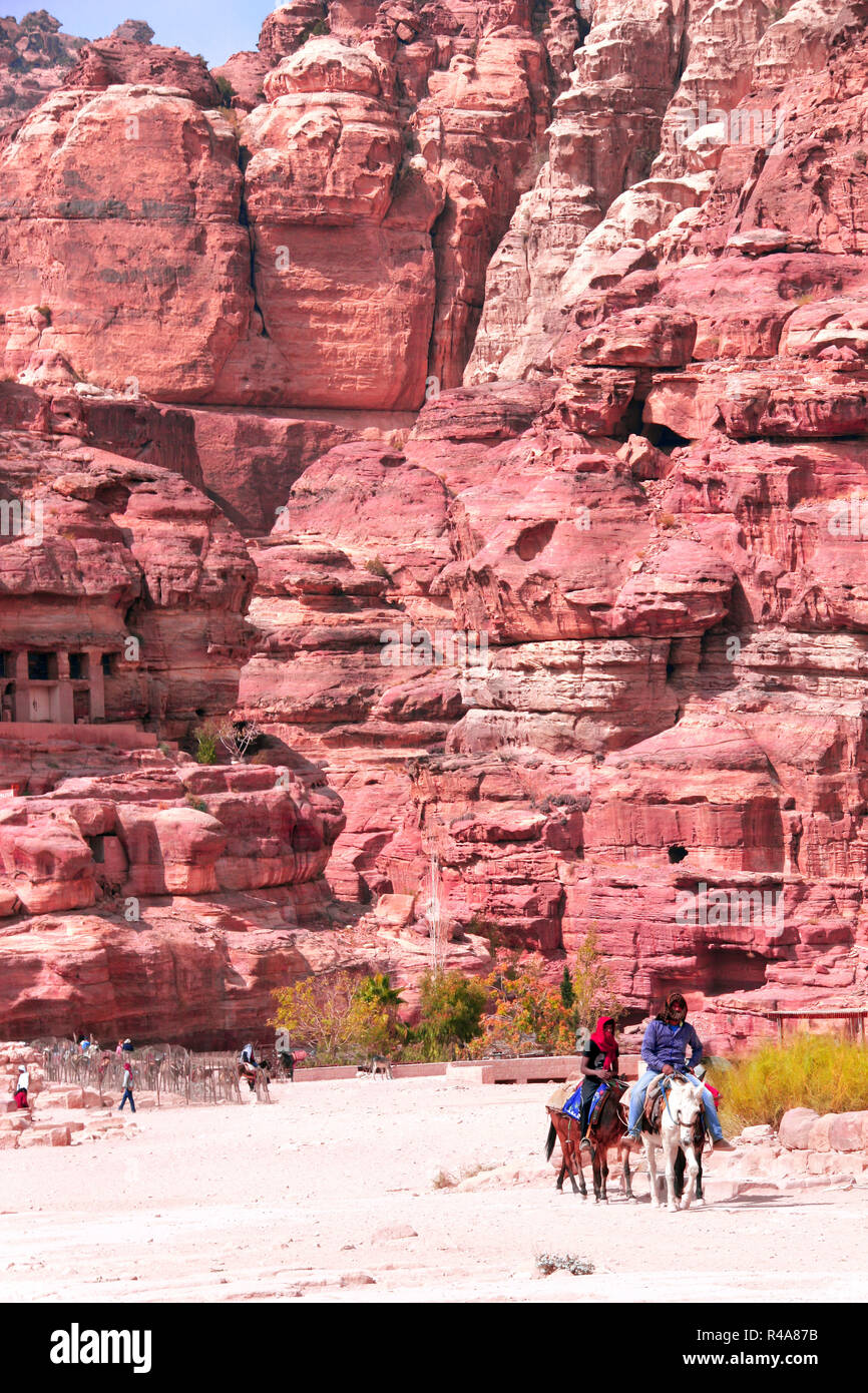 I turisti di marcia su asini in Petra (Red Rose City), Giordania. Patrimonio mondiale dell UNESCO Foto Stock
