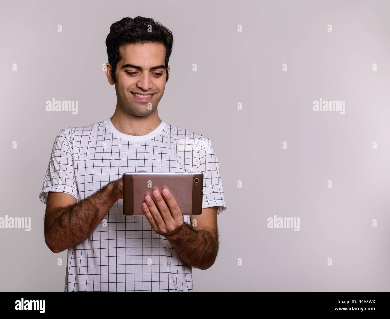 Ritratto di giovane felice persiano di uomo con tavoletta digitale Foto Stock