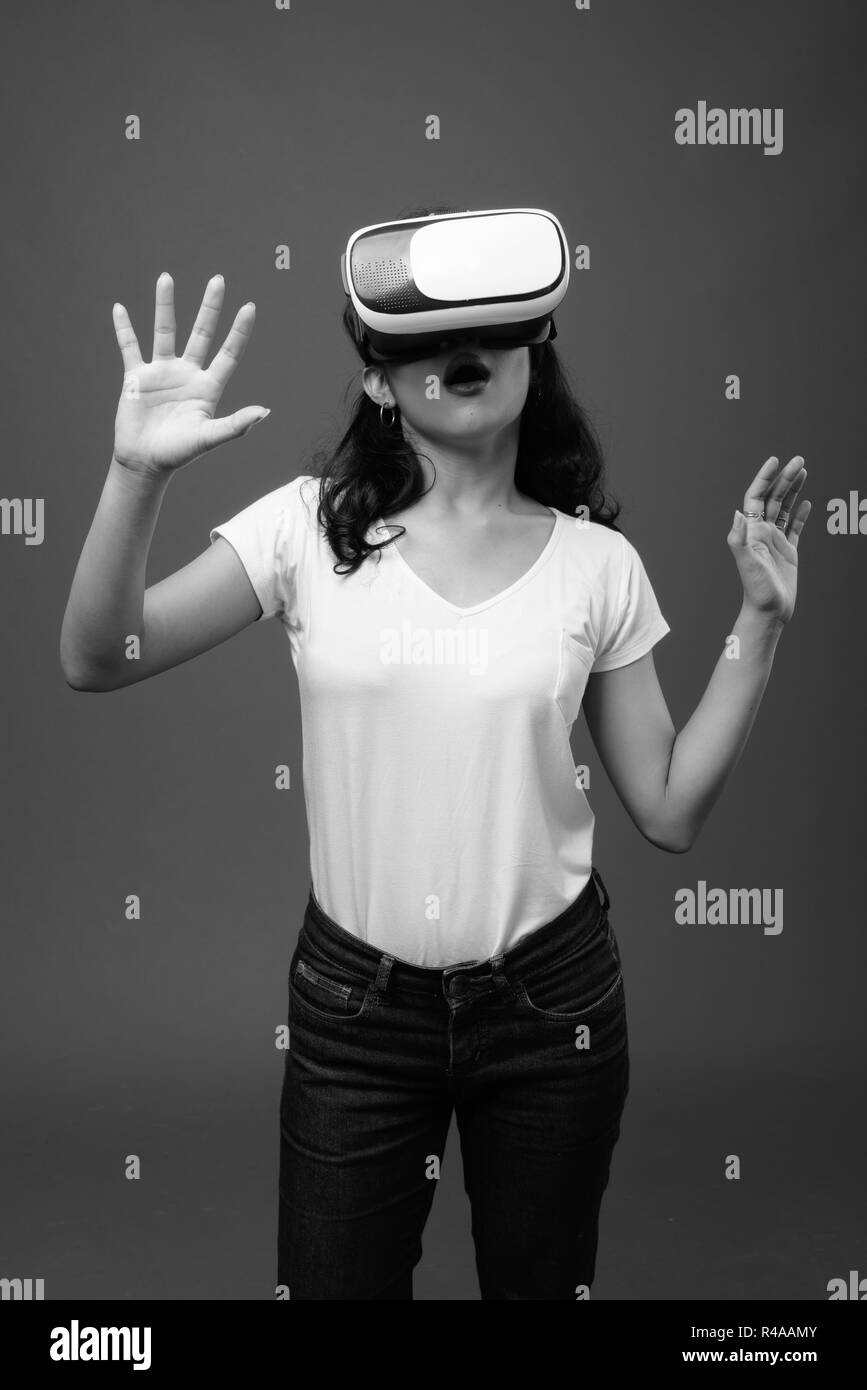 Giovane bella donna asiatica utilizzando occhiali per realtà virtuale Foto Stock